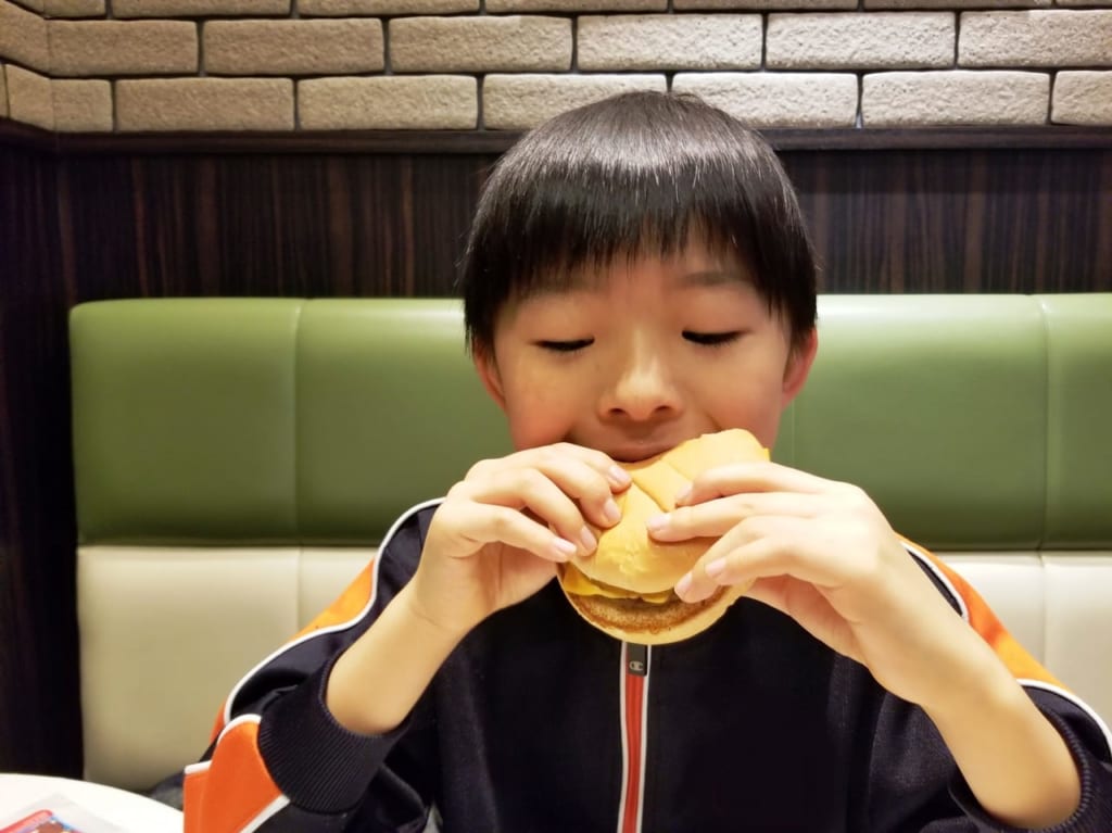 ハンバーガーを食べる子供の画像